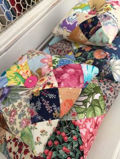 several colorful pillows sitting on top of a window sill