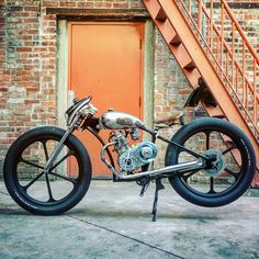 a motorcycle parked in front of a brick building next to a set of stair steps