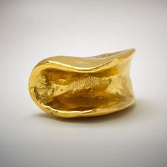 a close up of a gold ring on a white surface