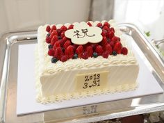 a cake with white frosting and strawberries on top is sitting on a tray