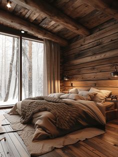 a bedroom with wood walls and flooring has a large bed in the corner that is surrounded by wooden planks