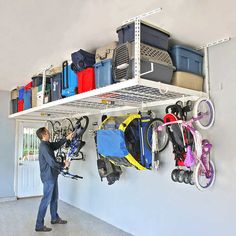 a man standing in front of a wall filled with lots of luggage and bike parts