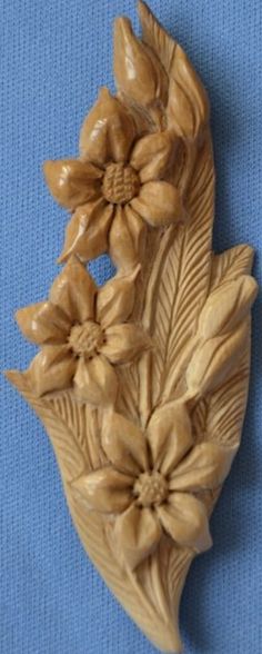 carved wood flowers and leaves on a blue background