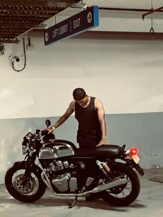 a man standing next to a motorcycle in a garage