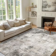 a living room filled with furniture and a large rug on top of a hard wood floor