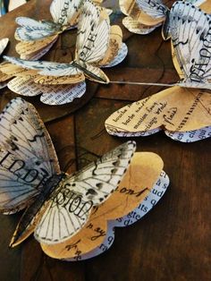 several butterflies are sitting on top of a wooden table with letters and numbers written on them