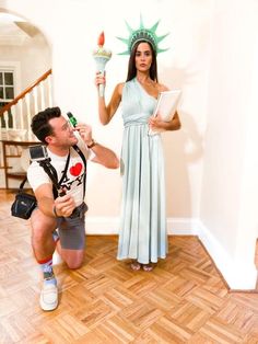 a man and woman dressed as the statue of liberty pose in front of an open doorway