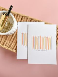 two greeting cards with the words happy birthday on them next to a pen and cup