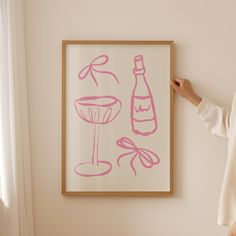 a woman standing in front of a painting with wine glasses and a bottle on it