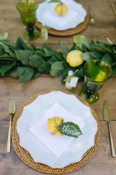 a place setting with lemons and greenery