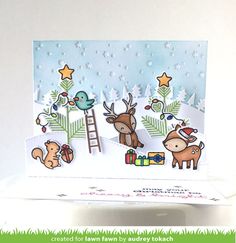 a handmade christmas card with animals and trees