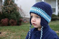 a young boy wearing a blue and white crocheted hat