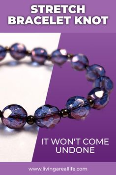 a bracelet that has been made with purple glass beads and is being displayed on a white table