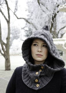 a woman wearing a gray knitted hood with buttons on the front and back of her head