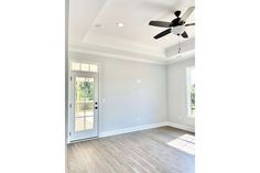 an empty living room with a ceiling fan