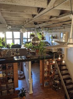 an overhead view of a living room and kitchen with stairs leading up to the second floor