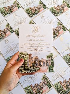 a person holding up a wedding card in front of many other cards