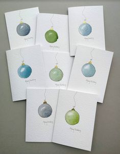 six christmas cards with ornaments hanging from them, all in different shades of green and blue