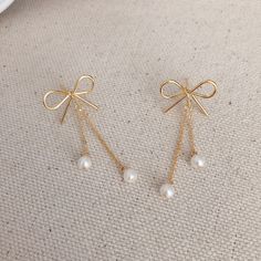 * DETAILS * - Shiny Gold Plated Ribbon Bow Earrings 17*13mm - Freshwater Round Pearls 4mm - Gold Plated Chain 🌟more ribbon earrings. Here is the link. https://www.etsy.com/JinnysJewelryBySeJin/listing/986389259/delicate-ribbon-bow-earrings-lovely?utm_source=Copy&utm_medium=ListingManager&utm_campaign=Share&utm_term=so.lmsm&share_time=1616484697112 https://www.etsy.com/JinnysJewelryBySeJin/listing/983085149/ribbon-teardrop-dangle-earrings-bridal?utm_source=Copy&utm_medium=Lis Bow Pearl Earrings, Cute Dangle Earrings, Ribbon Earrings, Bridesmaids Earrings, Bridesmaids Jewelry, Preppy Jewelry, Pretty Jewelry Necklaces, Christmas Gift Basket Ideas