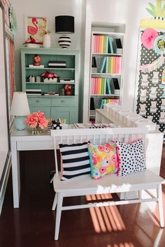 a white bench sitting in front of a book shelf filled with lots of colorful books