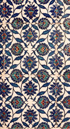 an intricately designed tile with blue and red designs on it's sides,