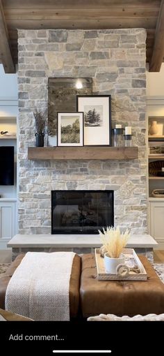 a living room with stone fireplace and built - in entertainment center, coffee table and ottoman