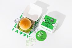 a hamburger sitting on top of a white table next to a green and white sticker