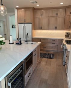 a kitchen with white counter tops and wooden cabinets