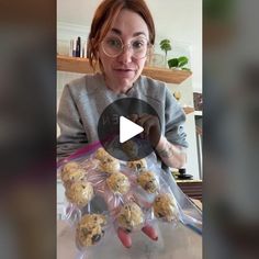 a woman with glasses is holding up some cookies