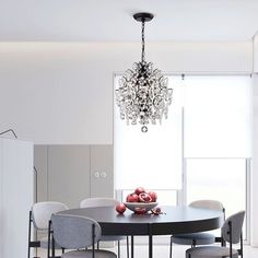 a dining room table with chairs and a chandelier hanging from the ceiling