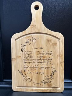 a cutting board with an engraved poem on the front and back side, sitting on a shelf