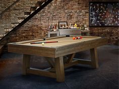 a pool table in front of a brick wall