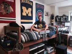 a man sitting on top of a bed in a room filled with sports related items