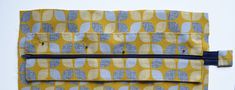 a yellow and blue patterned piece of fabric with zippered closures on the side