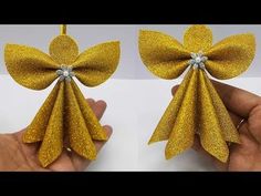 two gold bows are being held by someone's hand