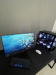 a desk with a keyboard, monitor and mouse on it next to a computer screen