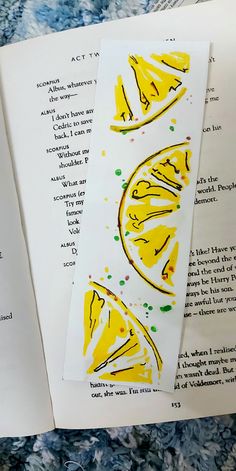 an open book with drawings on it and some papers next to it that have pictures of lemons painted on them