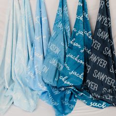 three blue and one white towels hanging on a wall with the words swager printed on them