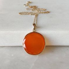 ITEM DESCRIPTION: >> The Pendant is made from Solid 14K Yellow Gold. Gemstone used is absolutely natural and ethically sourced. >> Natural Flat Cut Red Onyx in round shape and bezel setting is studded on it with utmost precision. >> This is a minimalist design and is absolutely hassle-free and everyday jewelry. Gem: Red Onyx Gem size: 20mm Round Gem weight: 9.27 carats Gold purity: 14K (58.33% approx.) Gold weight: 0.59 grams Gross weight: 2.44 grams The Gold purity is guarante Orange Gemstone Pendant Jewelry, Orange Round Pendant Jewelry For Formal Occasions, Classic Orange Necklace For Gift, Classic Orange Necklace For Gifts, Yellow Gold Carnelian Jewelry With Polished Finish, Orange Gemstone Jewelry With Round Pendant, 14k Gold Orange Jewelry With Polished Finish, Orange 14k Gold Jewelry With Polished Finish, Elegant Carnelian Gemstones As A Gift