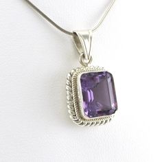 Large emerald cut 10x12mm genuine amethyst gemstone is set in sterling silver in Nepal. Handmade blue topaz pendant is 1 1/8 inches long and 5/8 inch wide and is sold separate from the snake chain shown. To clean pendant: simply use a jewelry polishing cloth to brighten the silver. Style Number: 7732 Metal: 925 Sterling Silver Gemstone: Genuine Amethyst Dimensions: 1 1/8 inches long and 5/8 inch wide Handmade in Nepal Fine Jewelry With Rectangular Gemstone Accents, Fine Jewelry With Gemstone Accents Rectangular Shape, Rectangular Gemstone Fine Jewelry, Formal Sterling Silver Rectangular Pendant, Classic Faceted Rectangular Jewelry, Classic Rectangular Faceted Jewelry, Sterling Silver Rectangular Pendant Fine Jewelry, Classic Jewelry With Gemstone Accents And Rectangular Stone, Fine Jewelry Sterling Silver Rectangular Pendant