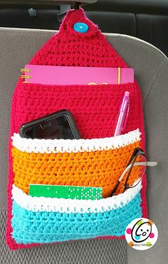 a cell phone in a crocheted purse on the back seat of a car