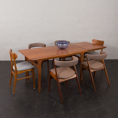 a wooden table with chairs around it and a bowl on the table in front of it