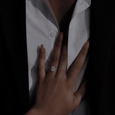 a close up of a person wearing a ring on their left hand and holding onto his shirt