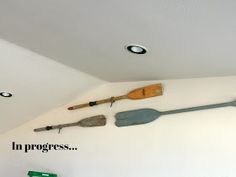 there are many tools hanging on the wall in this room, including shovels and paddles