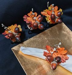 decorative fall leaves and acorns are placed on a gold plate