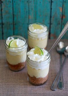 three small mason jars filled with key lime cheesecakes and topped with whipped cream