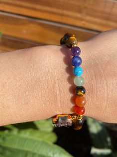 This is a beautiful bracelet with 7 chakra stones and a hamsa hand, made out of tiger's eye gemstone. The stones are known to help heal and balance one's chakras, and the hamsa is a symbol of protection. Perfect for anyone seeking inner peace and balance. Associated Chakras: 2nd (Sacral Chakra) or 3rd (Solar Plexus Chakra) Zodiac Signs: Virgo, Leo Elements: Air, Earth MANTRA: “I am motivated by my divine purpose and I manifest your vision with ease.” The Tiger's Eye crystal gets its healing prop Multicolor Natural Stones Spiritual Charm Bracelet, Spiritual Multicolor Charm Bracelet With Natural Stones, Adjustable Rainbow Stretch Bracelet, Spiritual Style, Adjustable Rainbow Stretch Bracelet Spiritual, Adjustable Rainbow Spiritual Stretch Bracelet, Rainbow Crystal Bracelet With Natural Stones For Healing, Spiritual Round Beads Charm Bracelet For Healing, Spiritual Charm Bracelet With 8mm Beads For Healing, Spiritual Rainbow Beaded Bracelets