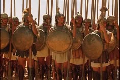 a group of men dressed in ancient roman armor and helmets standing next to each other