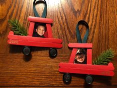 two red wooden toy cars decorated with pine branches