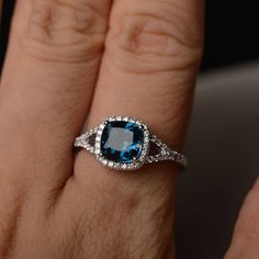 a woman's hand with a ring on it and a blue stone in the middle